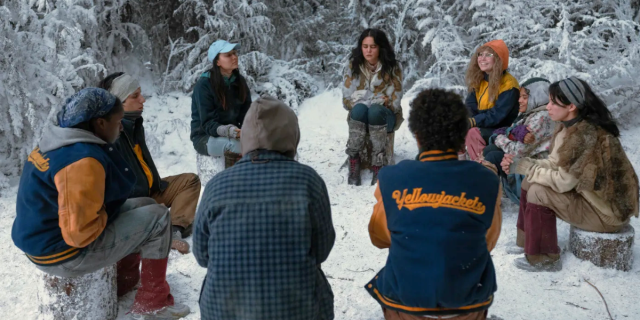 the Yellowjackets sit in a circle in the snowy wilderness