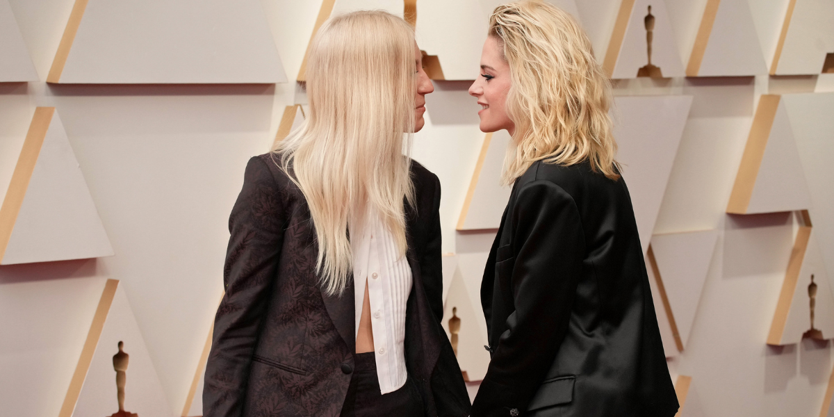 Dylan Meyer and Kristen Stewart leaning toward each other on the Oscars red carpet