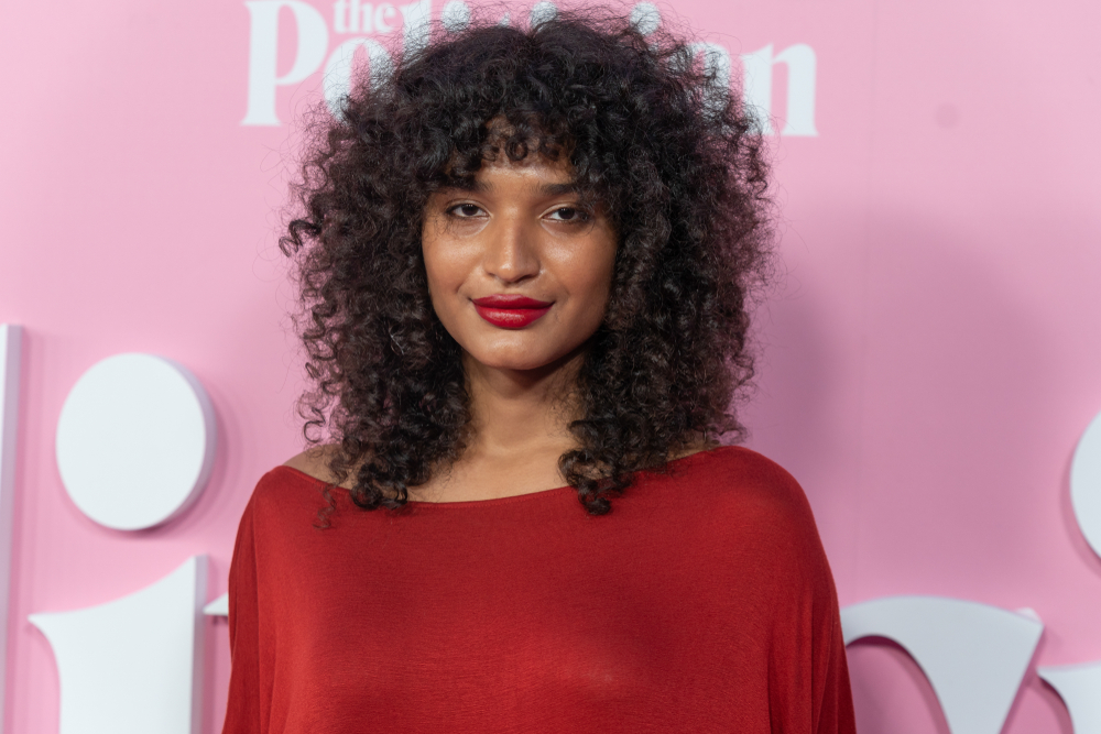 Indya Moore in a red top on the red carpet of the politician