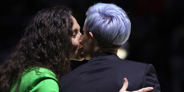 Sue Bird and Megan Rapinoe kiss during Sue Bird's jersey retirement ceremony after the game between the Seattle Storm and the Washington Mystics at Climate Pledge Arena