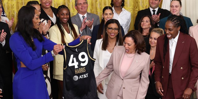 Las Vegas Aces' forward A'ja Wilson (L) and guard Chelsea Gray (R) present Vice President Kamala Harris with a jersey as Harris honors the 2022 WNBA Champion Las Vegas Aces, during a ceremony in the East Room on August 25, 2023 in Washington, DC. The Aces defeated the Connecticut Sun in 4 games to win the 2022 championship.