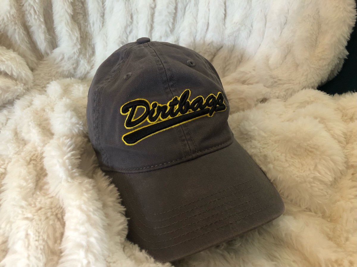 a gray hat that says DIRTBAGS on it