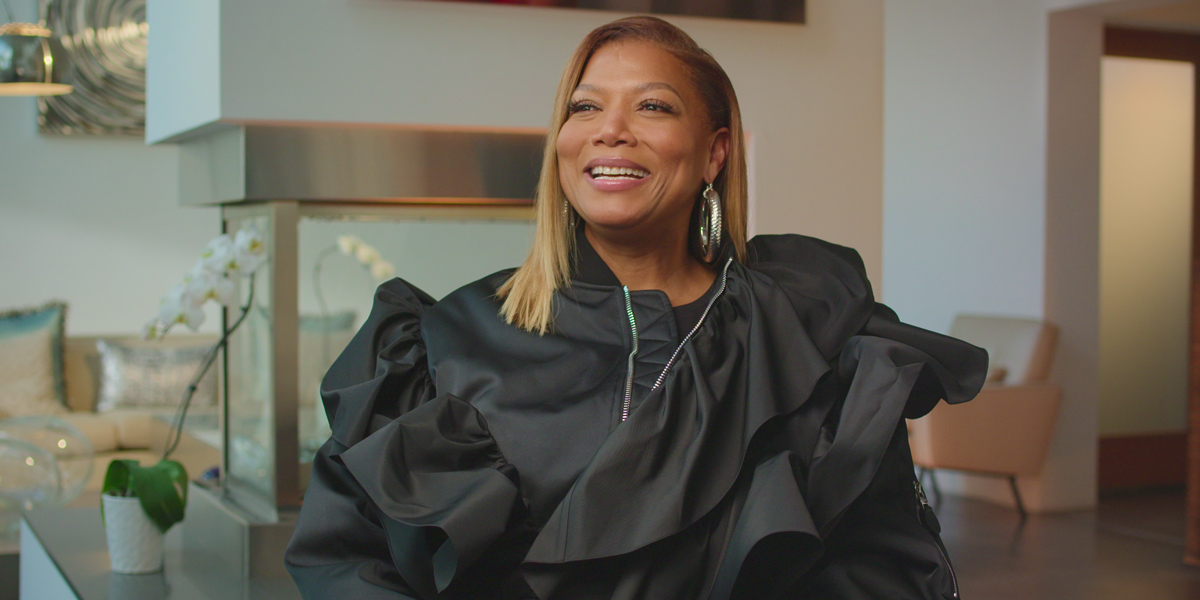 Queen Latifah is in a black fluffy gown and smiling in Netflix's Ladies First.