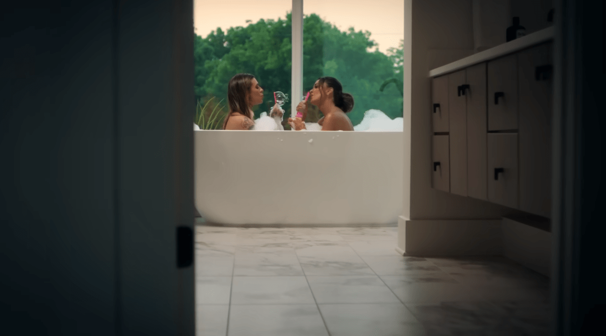 Morgan and Kyle in a tub blowing bubbles together in the Fall in Love With Me music video