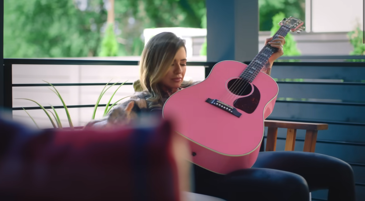 Morgan holding a pink guitar in the Fall in Love With Me music video