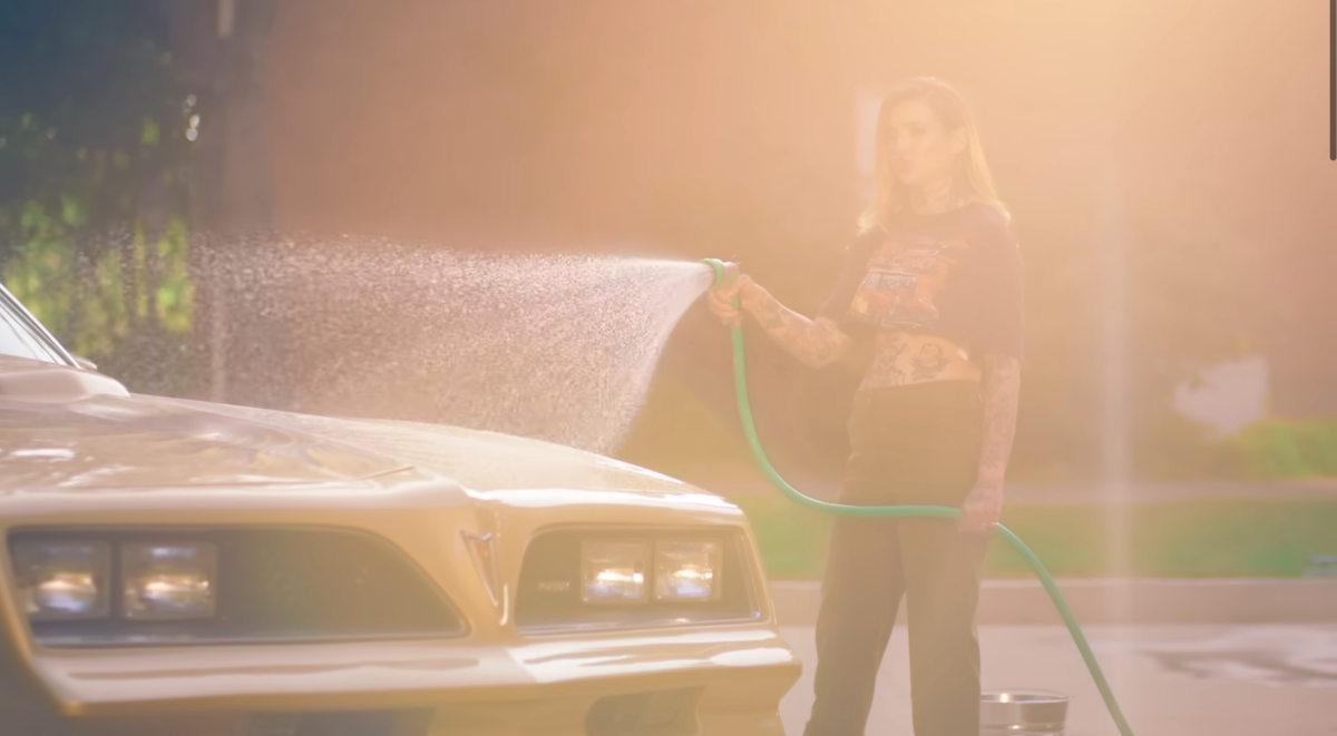 Morgan cleaning her car with a hose in the Fall in Love With Me music video