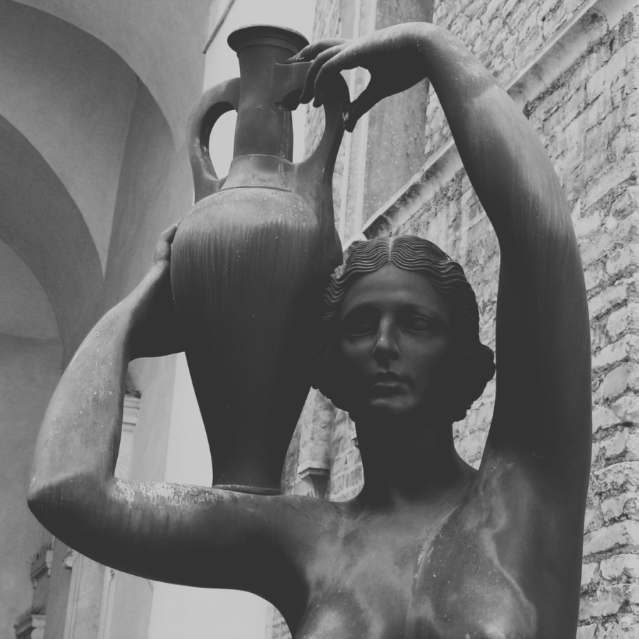 a black and white photo of a woman statue carrying an amphora