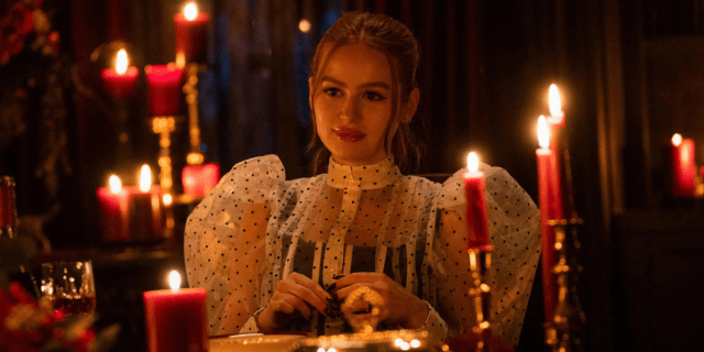Cheryl Blossom wearing puffy sleeves, surrounded by lit candles