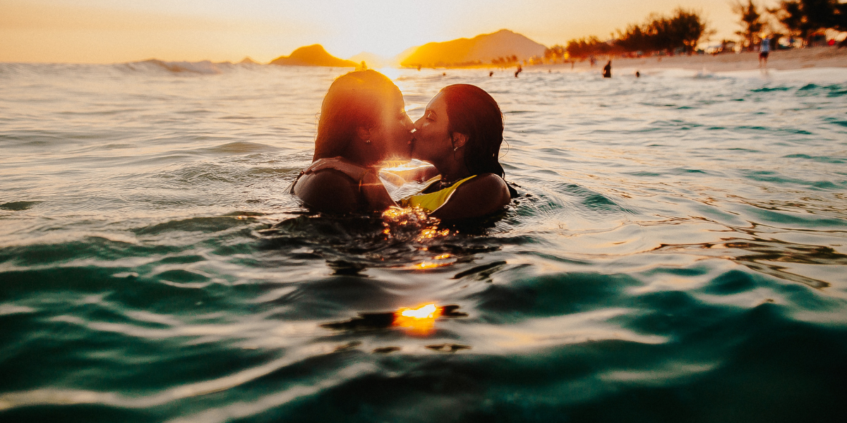 two women kissing in the ocean