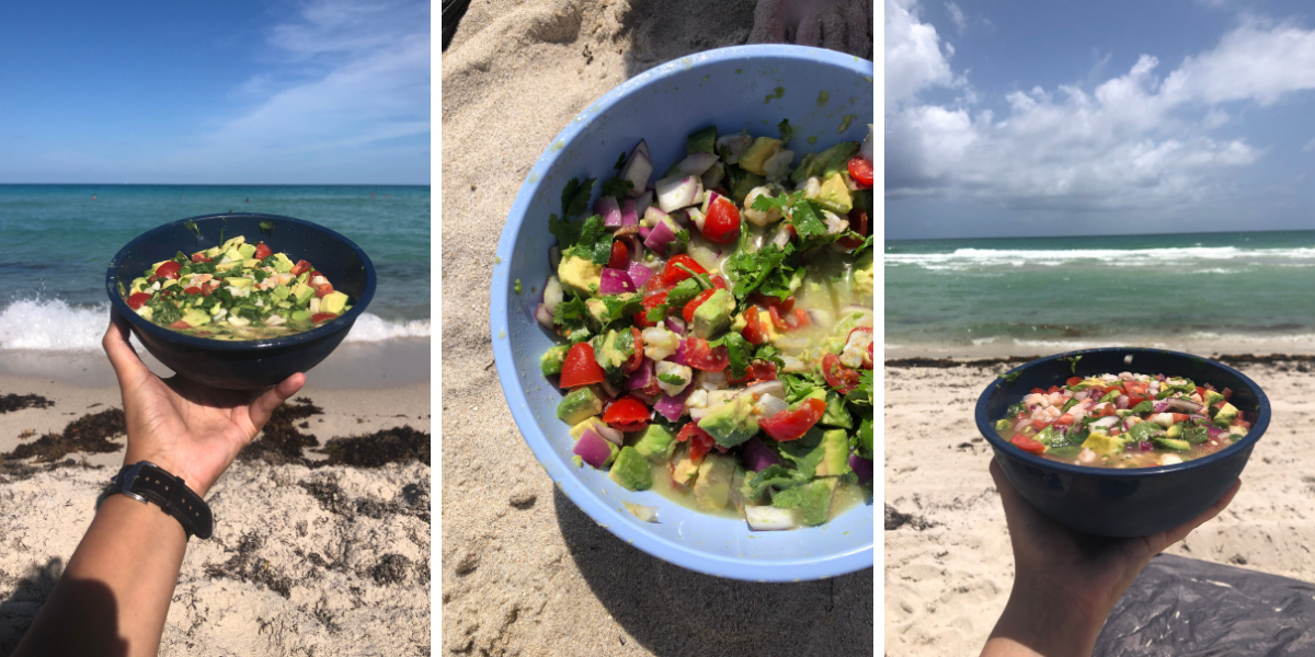 ceviche in a bowl being held out by a hand in front of the ocean on a beach