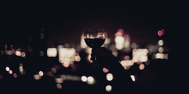 a glass of wine against city lights