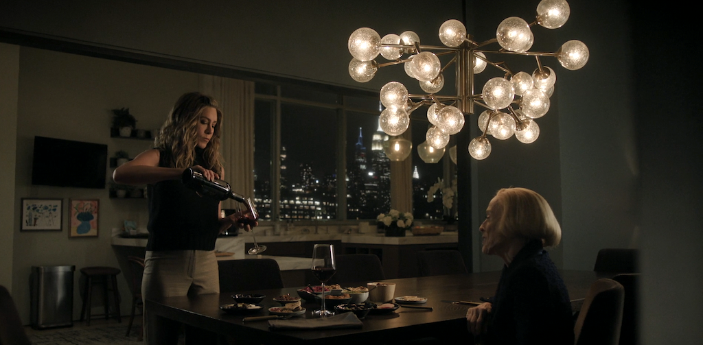 Jennifer Aniston and Hlland Taylor at a dining table in Alex Levy's apartment on The Morning Show