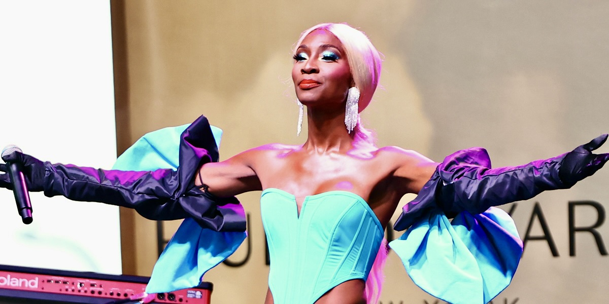 Actress Angelica Ross, who has announced that she's leaving Hollywood, on stage in a turquoise dress looking absolutely regal.
