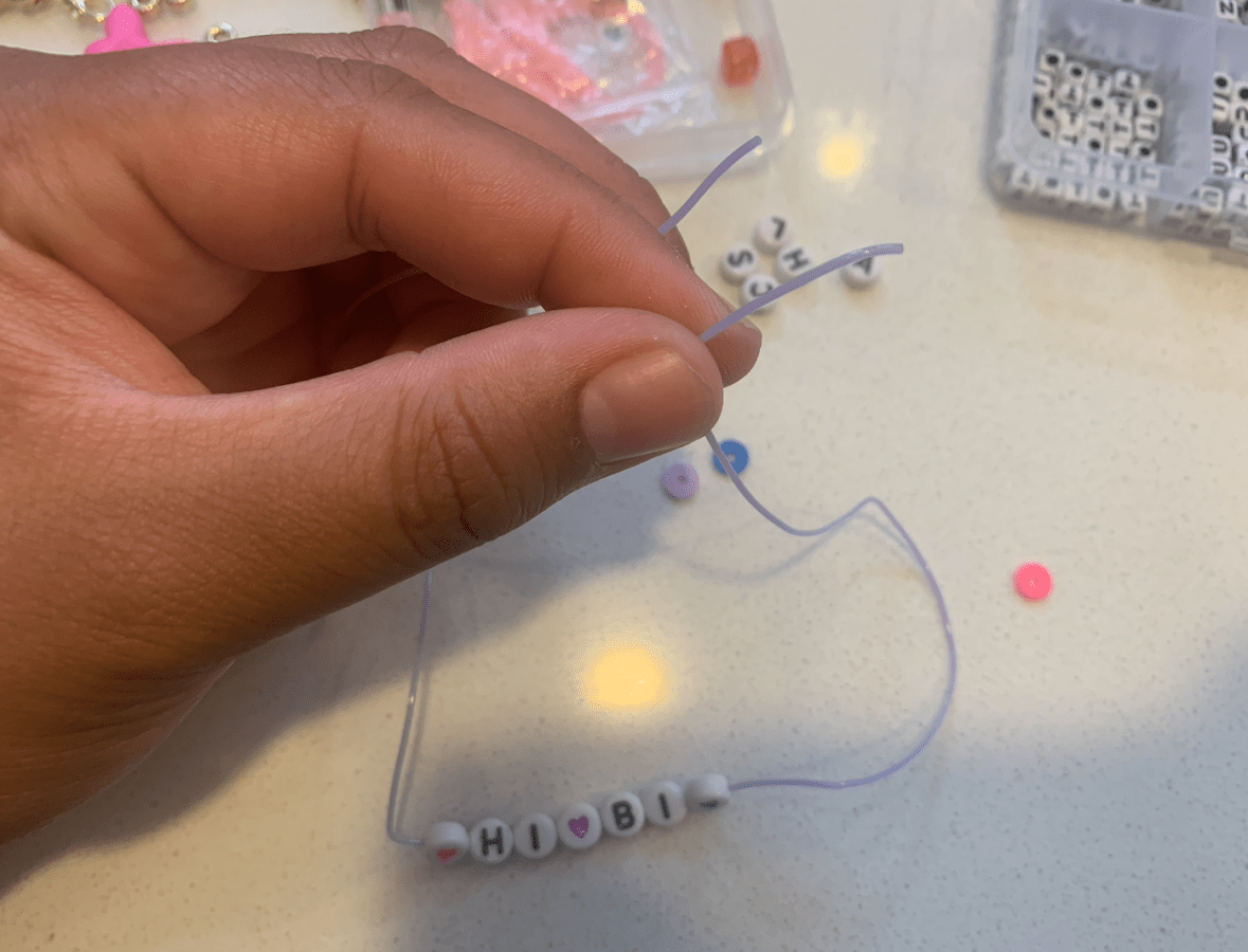 a string with HI BI spelled out in beads on it