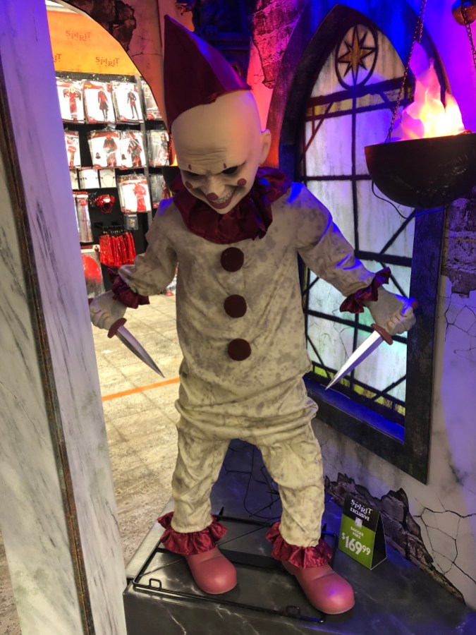 an animatronic that looks like a scary clown holding two daggers