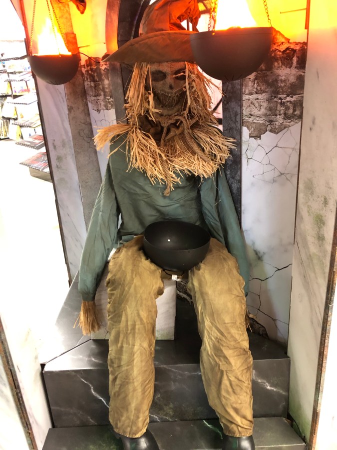 a haunted looking scarecrow in a sitting position