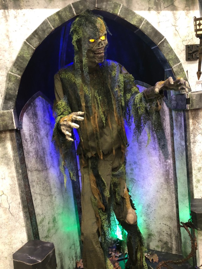 a zombie animatronic covered in seaweed/swampy stuff