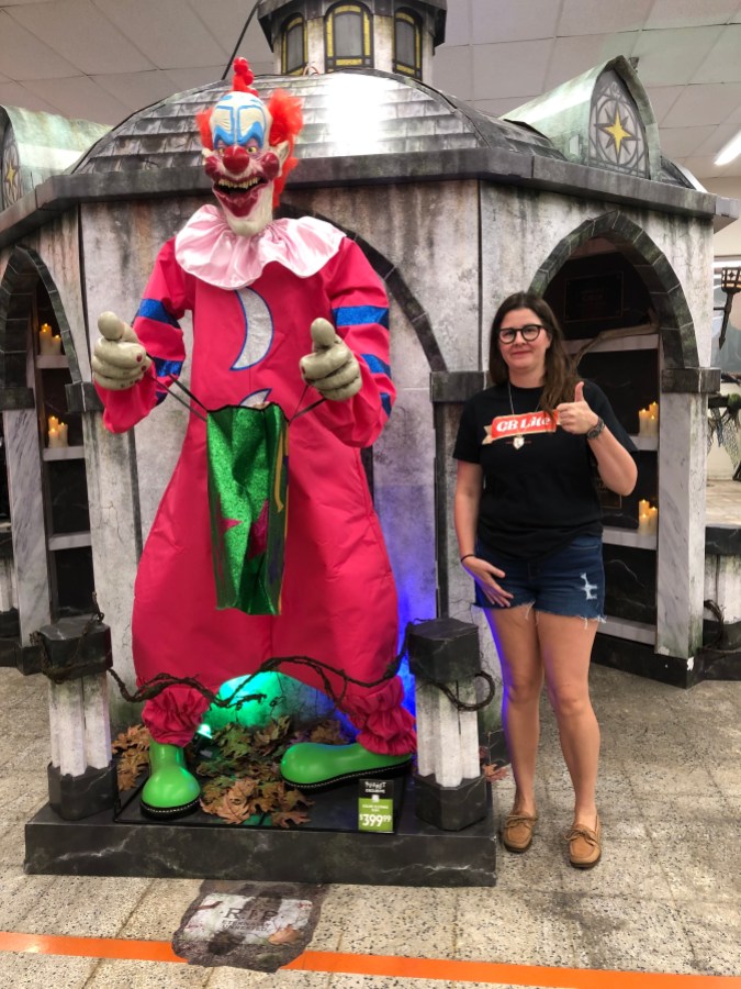 the author Kristen Arnett standing next to a giant scary clown animatronic