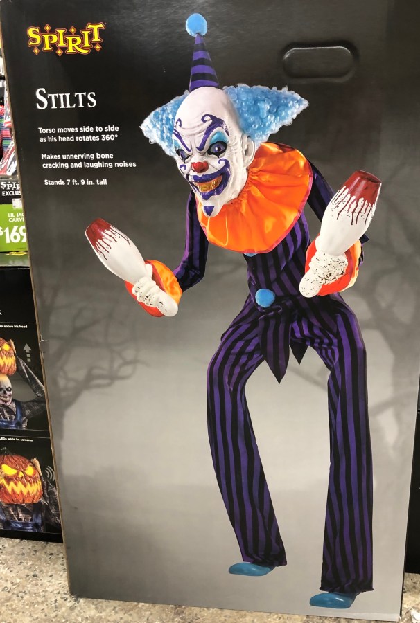 a scary clown animatronic holding bloody bowling pins