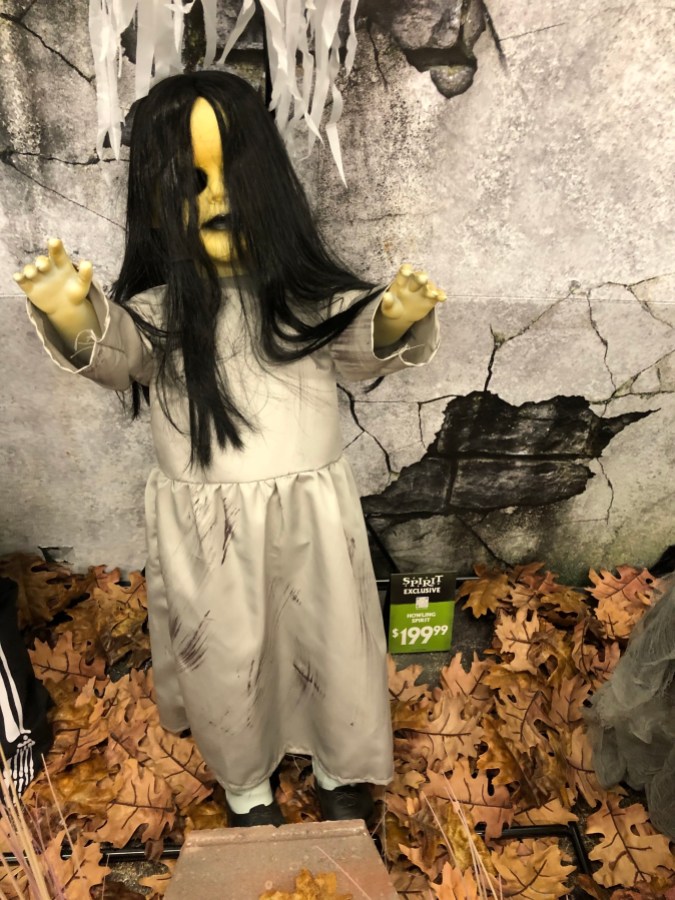 an animatronic that looks like a creepy girl with long black hair and a white tattered dress