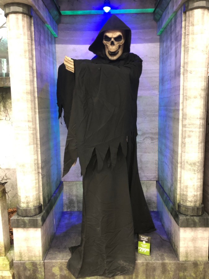 a skeleton looking animatronic with a long black cloak