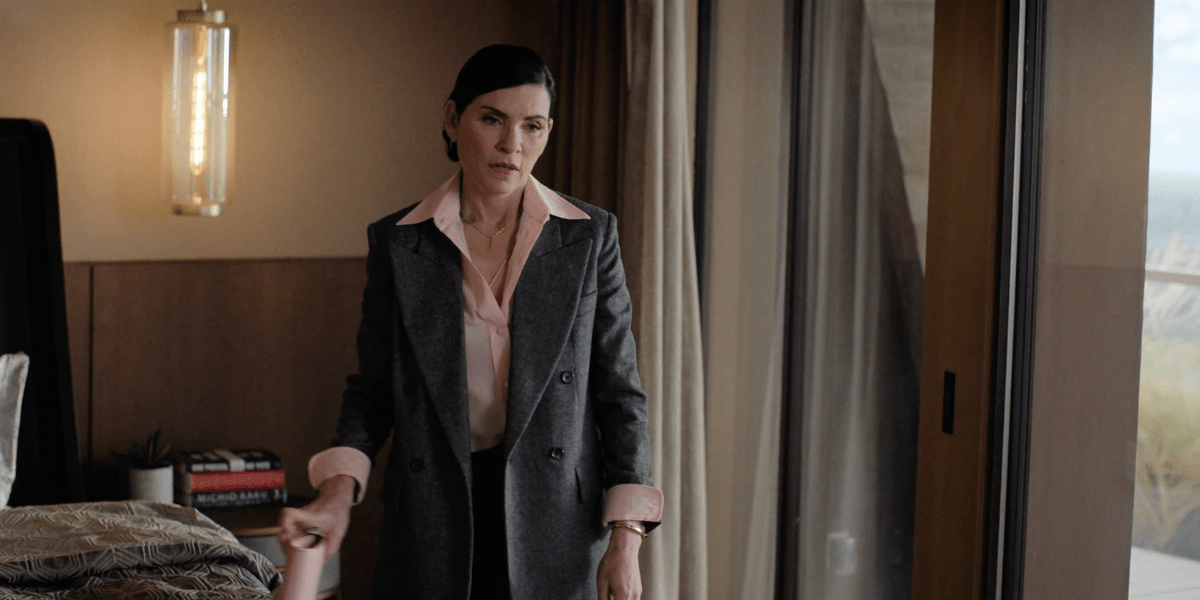 Julianna Margulies wearing a wide collar pink blouse and oversized gray blazer, looking disappointed on The Morning Show 304