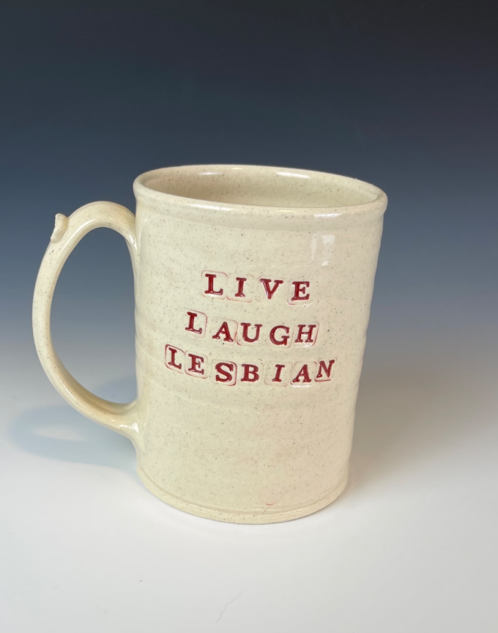 a beige ceramic mug that says LIVE LAUGH LESBIAN