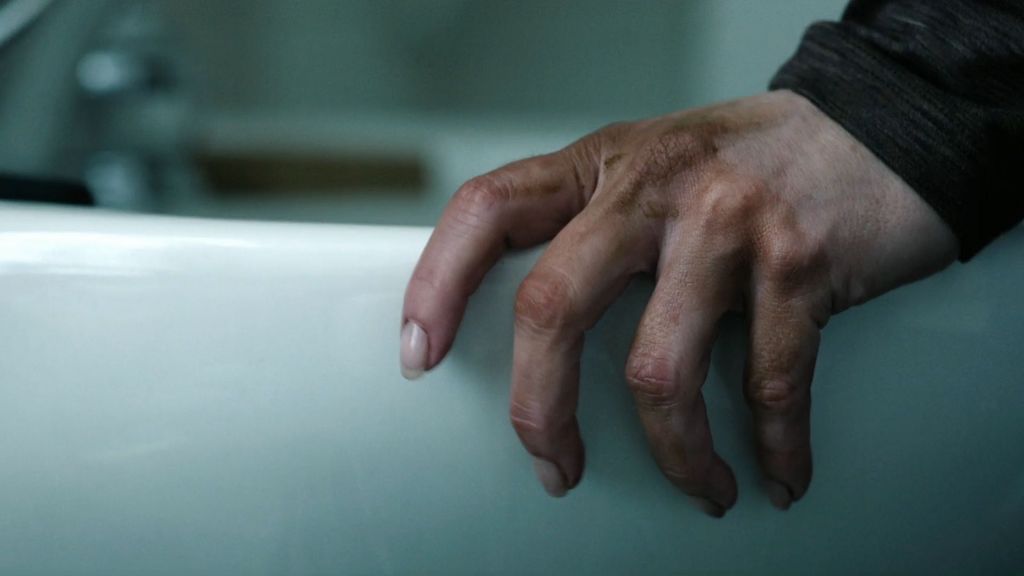 a hand on a sink or a bathtub