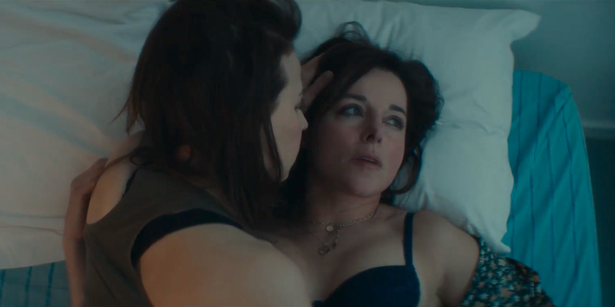 Laura Calamy and Suzanne Clément lie in bed together. Clément looks at Calamy as Calamy looks off.