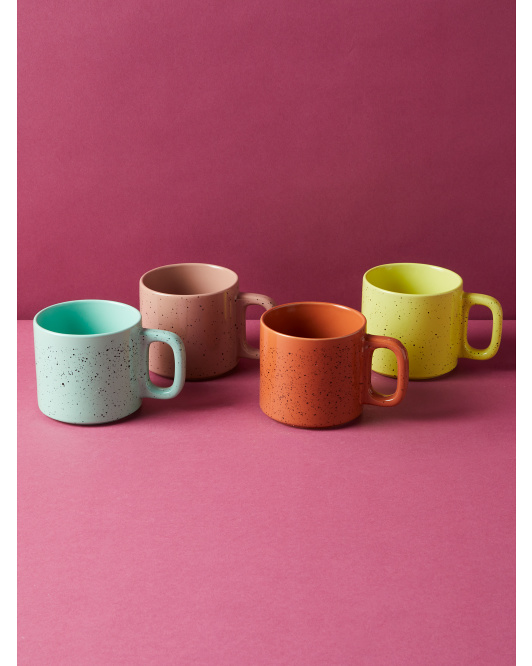 a set of four speckled mugs in blue, pink, orange, and yellow