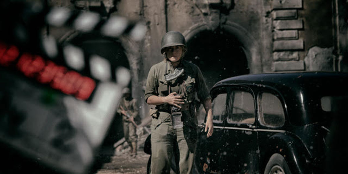 Kate Winslet is dressed in WWII military gear in a wide shot.