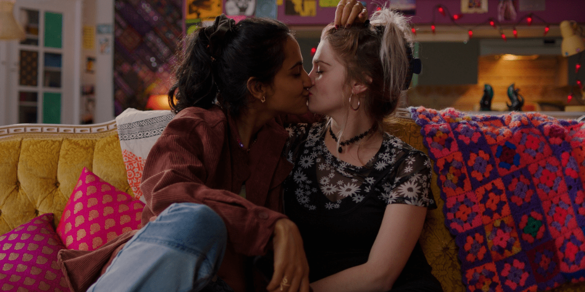 In The Queen of My Dreams, a South Asian woman and a white woman kiss on a couch.