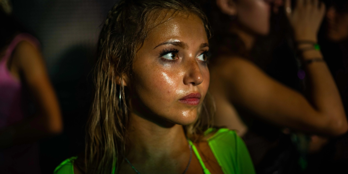 How to Have Sex: a blonde white teen girl stands in a club, covered in sweat