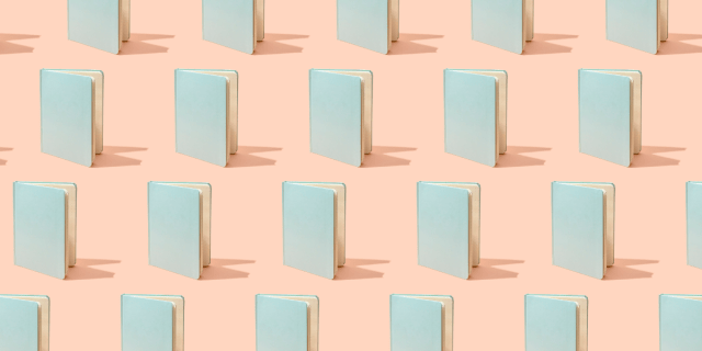 a bunch of blue notebooks against a pink backgorund