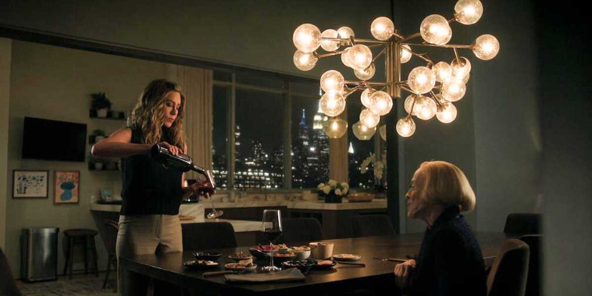 Jennifer Aniston and Holland Taylor in a kitchen on The Morning Show. Jennifer Aniston is pouring wine.