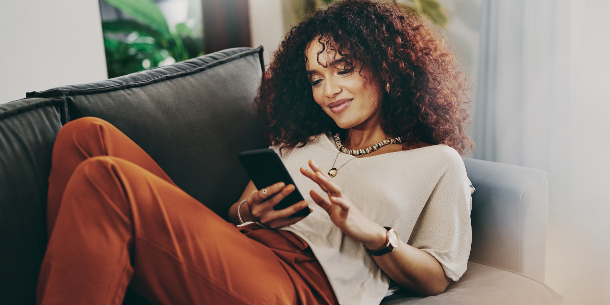 woman with brown curly hair scrolling on phone