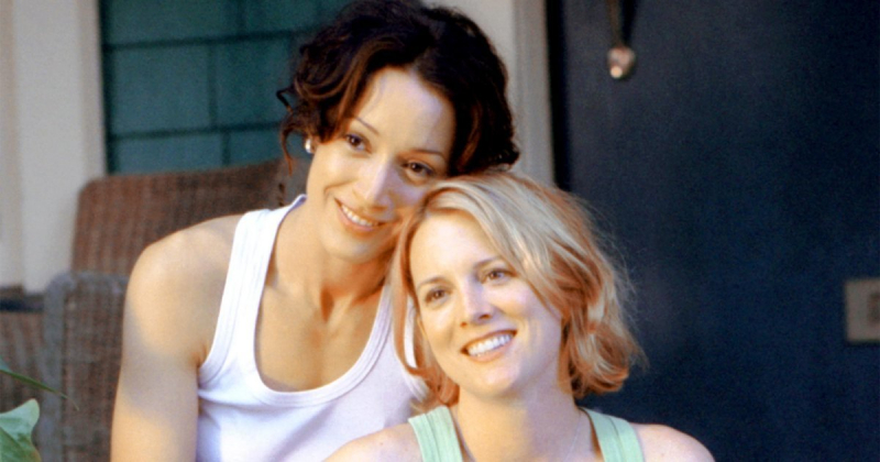 Toxic ships: Bette and Tina from the pilot smiling with their heads together on the porch.