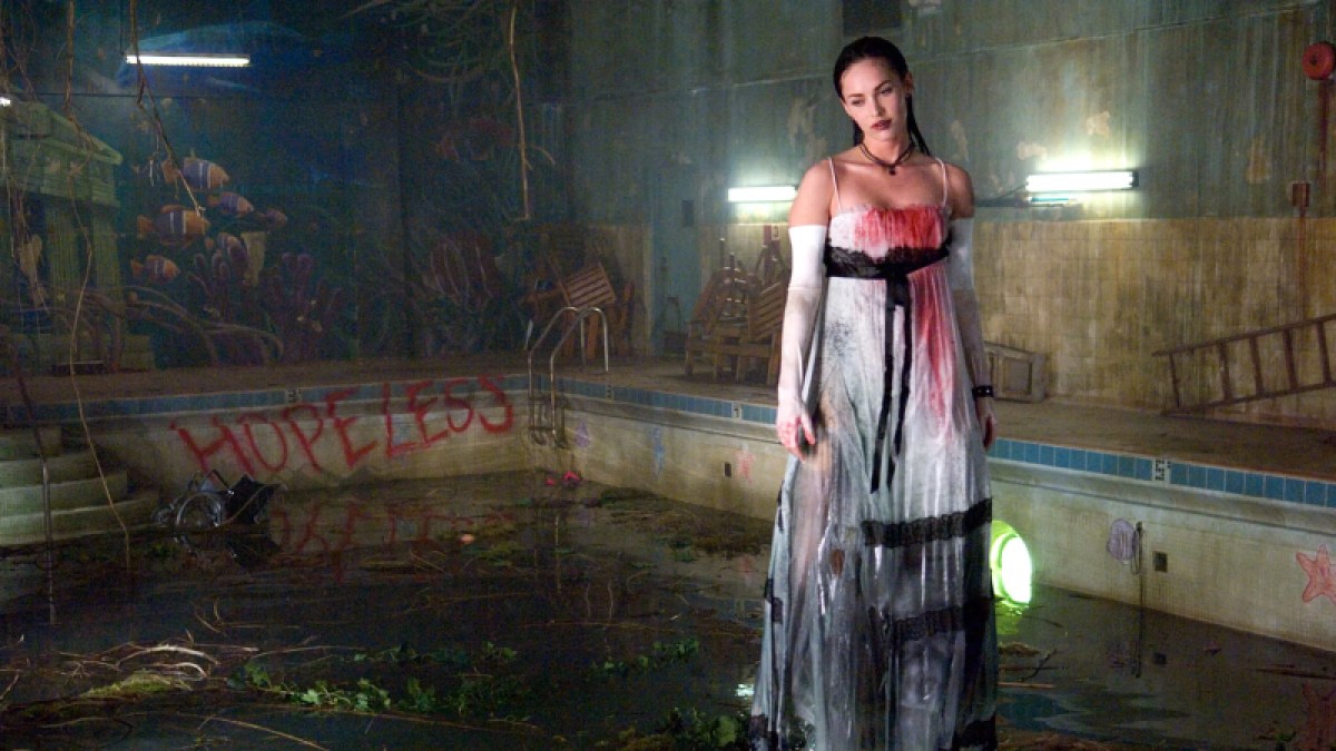 Queer horror to stream: Jennifer's Body. Jennifer Check in a white dress covered in blood in a swimming pool in Jennifer's Body
