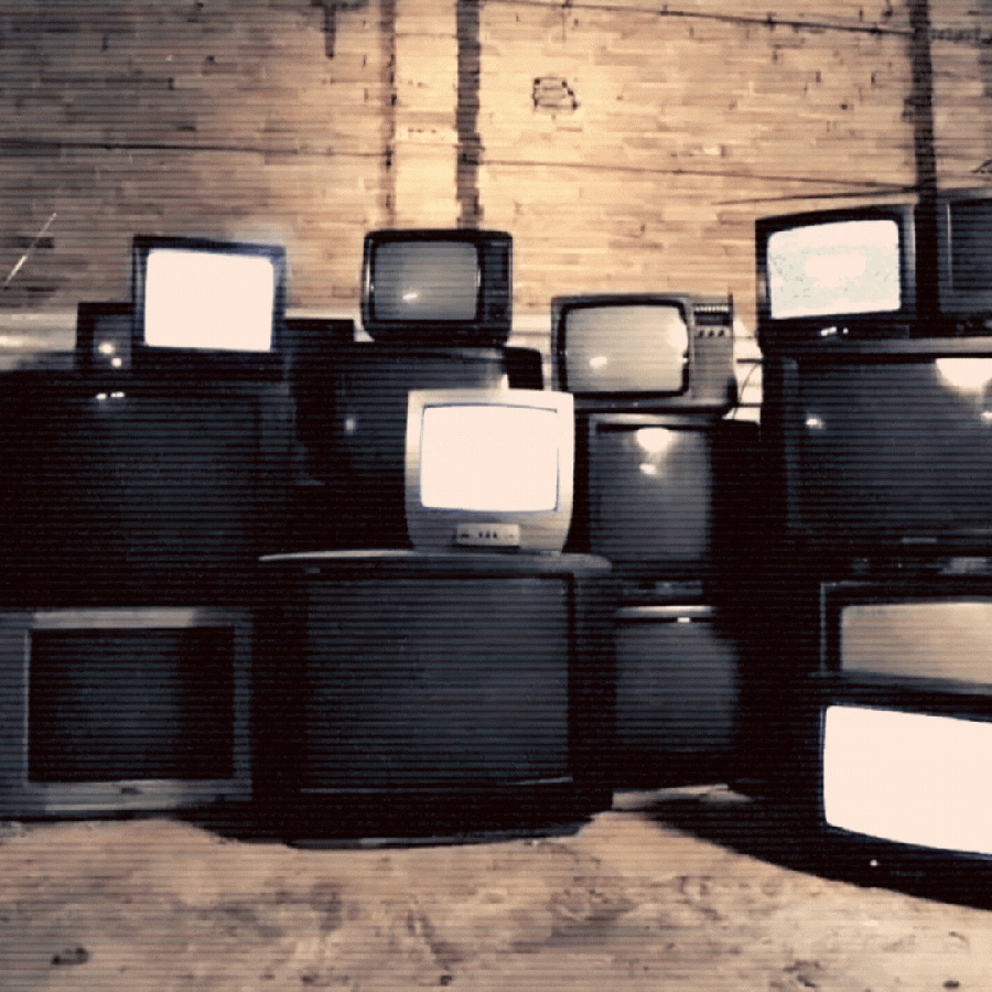 a gif of many flickering staticy tv screens in a warehouse. it's scary