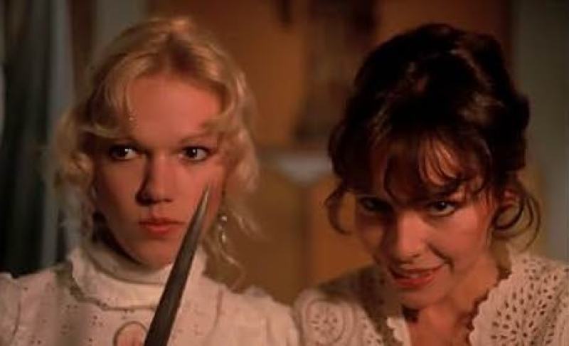 two vampires in white nightgowns, and one is holding a knife