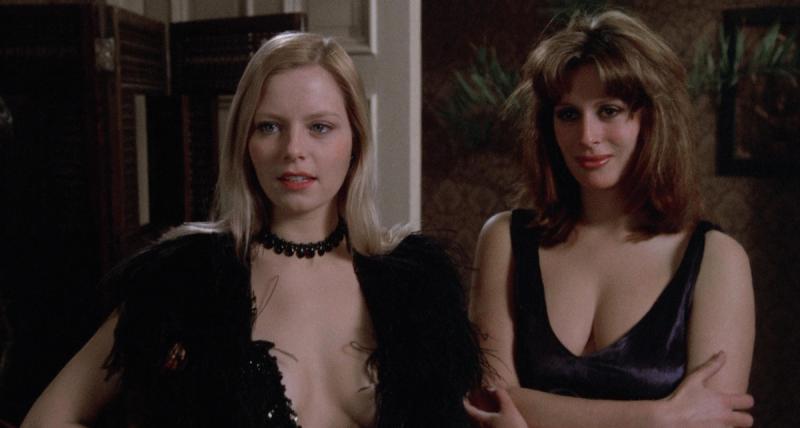 two white vampire women standing next to each other in black dresses
