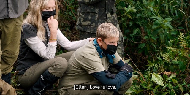 Ellen and Portia crouch down near the gorillas wearing masks. CC: [Ellen] Love is love.