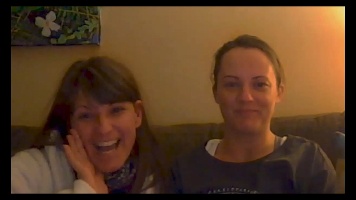 a lesbian couple on a zoom call, looking happy