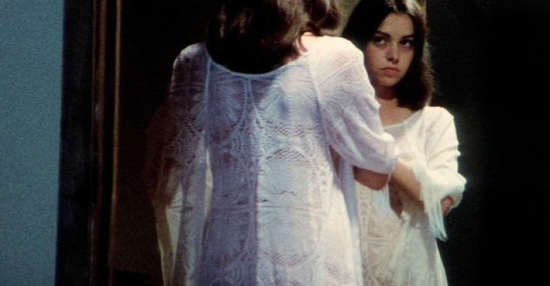 a vampire looks in a mirror in the movie Female Vampire. she is wearing a white lacey nightgown