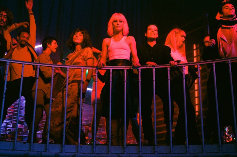 a bunch of queers stand on a balcony at a gay club in the film Knife + Heart