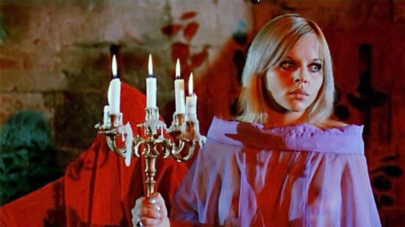 a vampire woman holds a candelabra