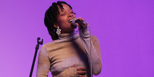 Jamila Woods singing at a microphone