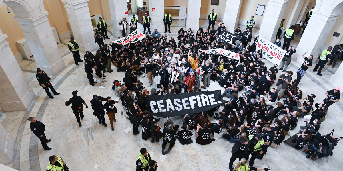 a group of Jewish activists with Jewish Voice of Peace gathers in the Capitol building in Washington with signs that say CEASEFIRE