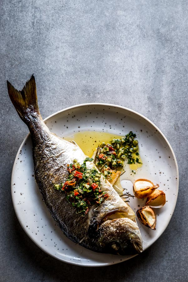a plate with a whole fish on it