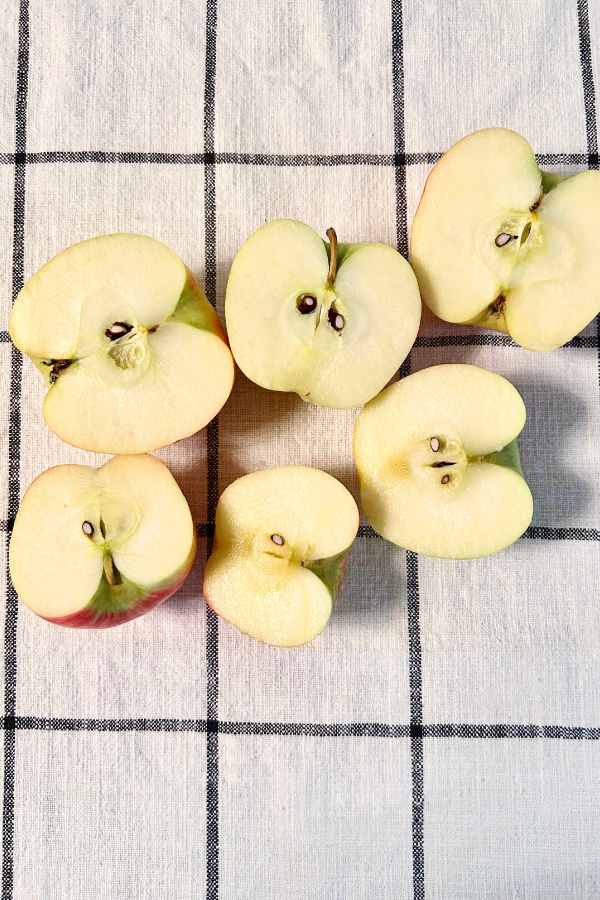 Cut up apples, piled on a checkered table cloth